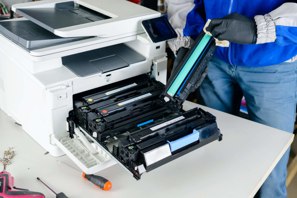 Technician cleaning rollers and printer components